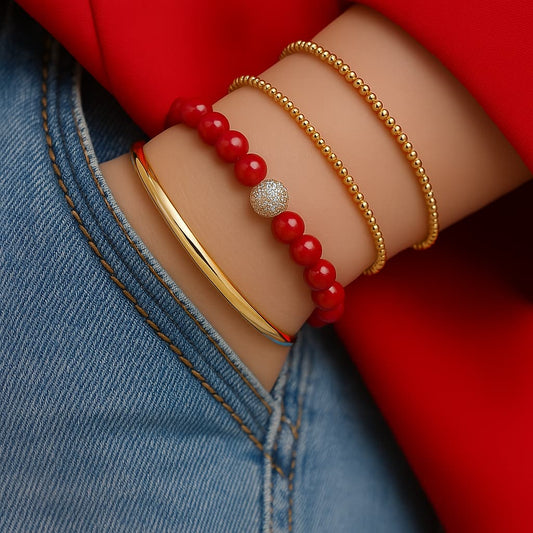 A woman wearing the Red Jasper Fortune Bracelet by GinaKimKR. Deep red natural stones and gold CZ details highlight bold energy and elegance.