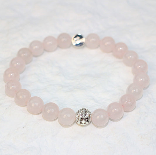Flat-lay image of the Rose Quartz Strength Bracelet with delicately polished pastel pink stones on a white background, designed for calming energy.
