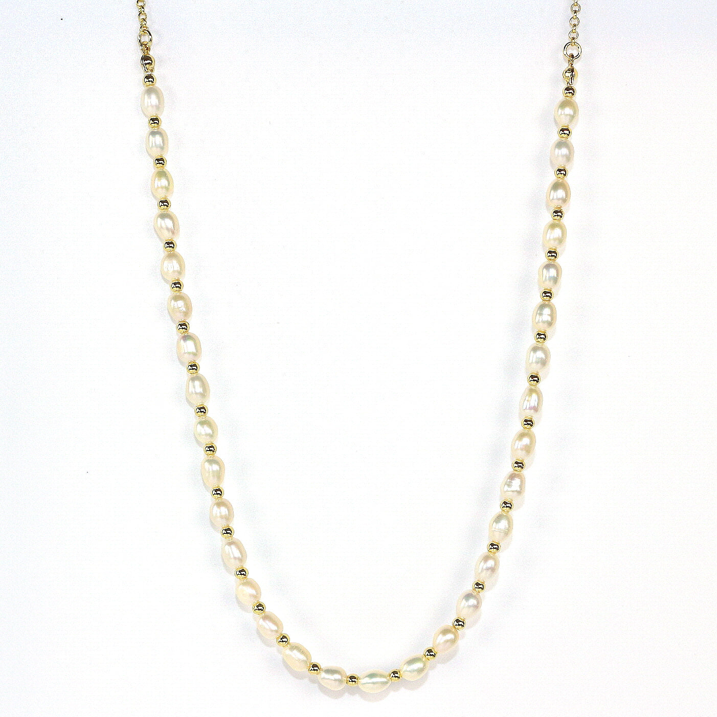 Flat lay photo of the Serenity Pearl Necklace by GinaKimKR, featuring freshwater pearls and gold-tone accents, styled on ivory satin for a luxurious, elegant look.