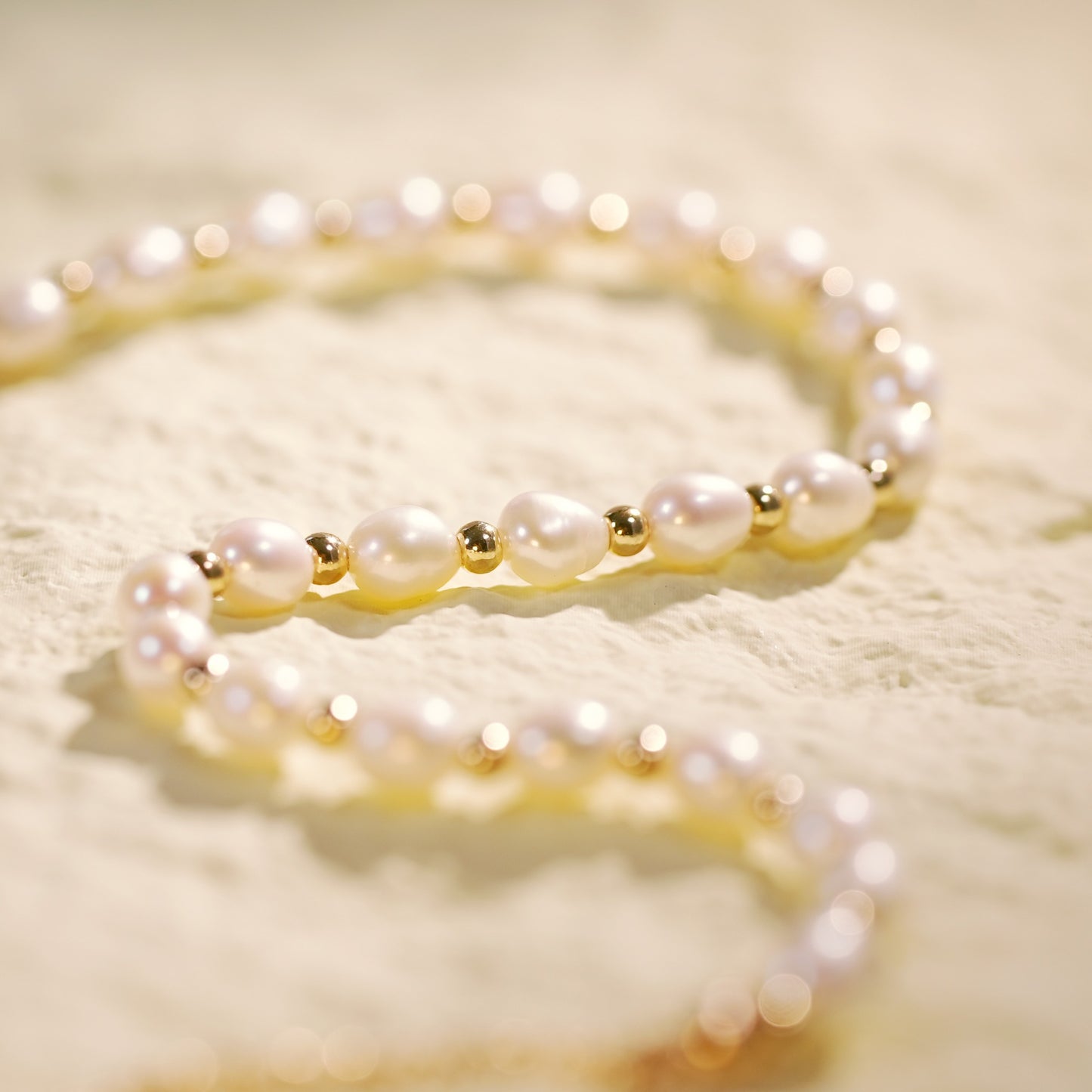 Zoomed-in view of the Serenity Pearl Necklace showing separated oval pearls and gold beads for a balanced, classic silhouette.