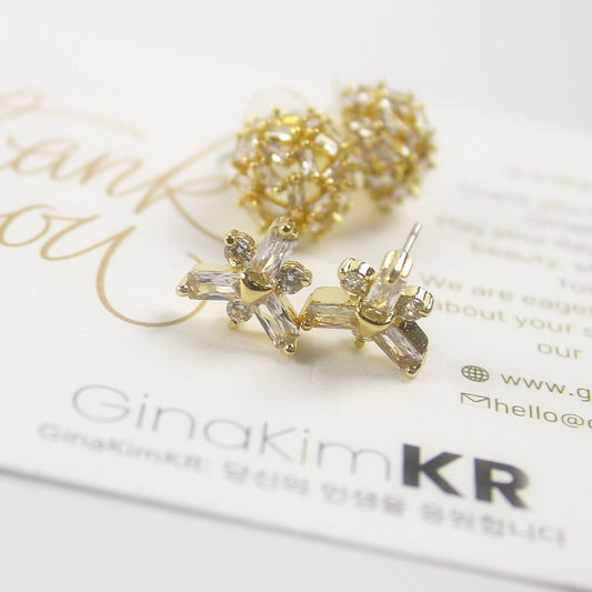 Close-up of GinaKimKR snowflake CZ stud earrings with dome studs in background, Korean minimalist jewelry