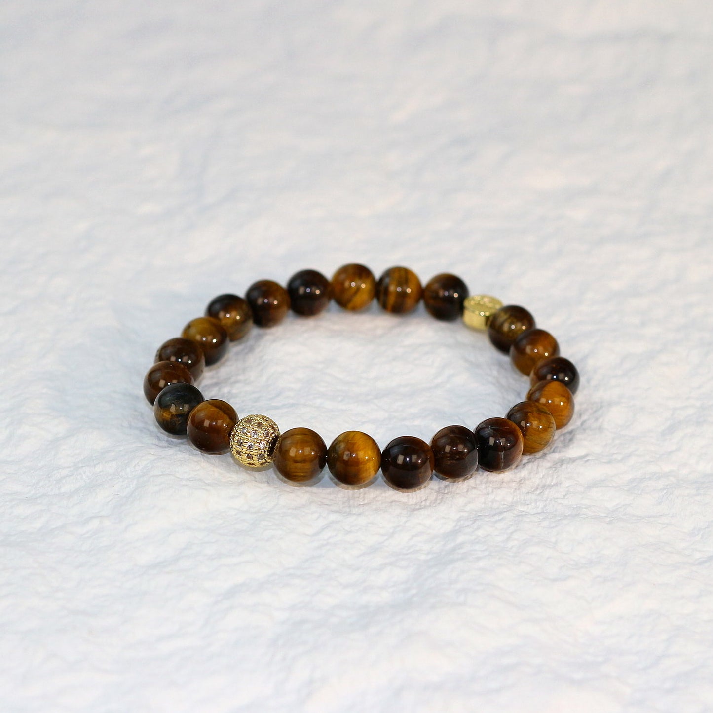 Flat-lay photo of the Tiger’s Eye Strength Bracelet with earthy golden brown tones and evenly spaced beads, displayed on a white background.