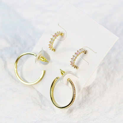 Blush Beam earrings styled on a soft fabric surface, showcasing gentle shine and rose gold details in natural light.