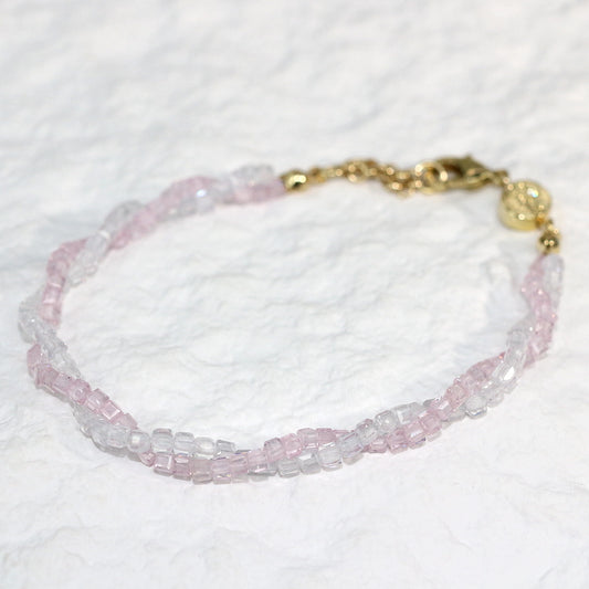 A close-up of the Blush Prism Bracelet, showcasing warm champagne-pink crystal beads with a luminous finish. The stretch bracelet features a sparkling CZ accent bead, styled on a woman’s wrist with soft natural lighting for an elegant, feminine look.