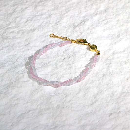 A close-up of the Blush Prism Bracelet, showcasing warm champagne-pink crystal beads with a luminous finish. The stretch bracelet features a sparkling CZ accent bead, styled on a woman’s wrist with soft natural lighting for an elegant, feminine look.