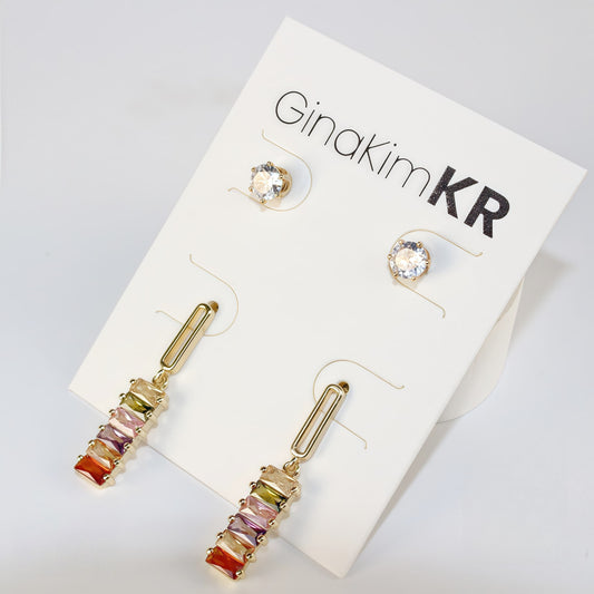 Angled shot of multicolor Lightfall Duo earrings with cylindrical beads and gold settings, shown in soft daylight.