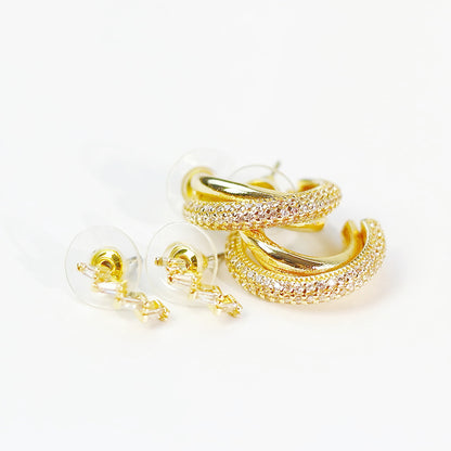 Close-up of Luna Curve Earring Set showing three pairs of gold-toned hoops and studs with smooth curved finishes.
