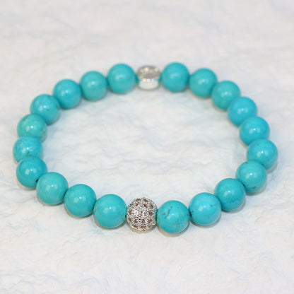 Angled view of the Turquoise Strength Bracelet with polished 8mm beads showing subtle natural patterns, crafted for everyday unisex wear.