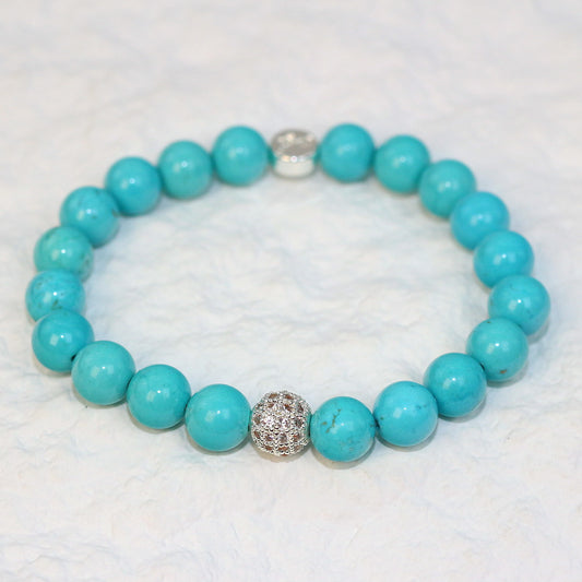 Angled view of the Turquoise Strength Bracelet with polished 8mm beads showing subtle natural patterns, crafted for everyday unisex wear.