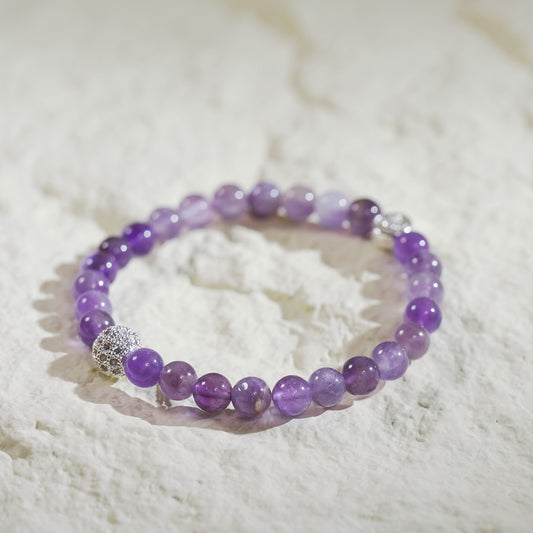 Handmade Korean amethyst fortune bracelet with gold-plated CZ bead and GinaKim logo charm. A calming gemstone bracelet for women’s everyday gift