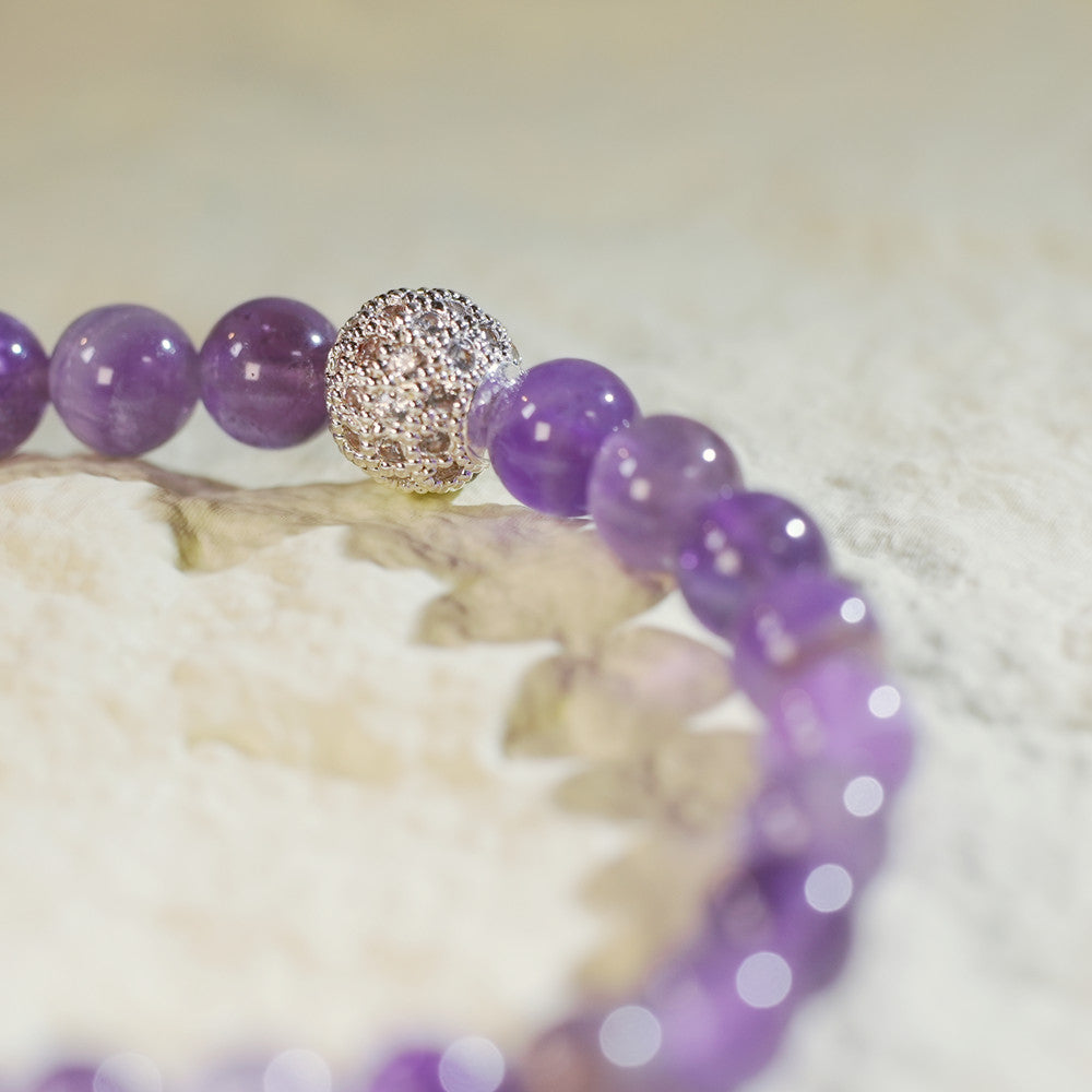 Close-up of the Amethyst Fortune Bracelet by GinaKimKR with faceted amethyst beads, CZ centerpiece, and gold-plated accents. Designed for serenity and balance.