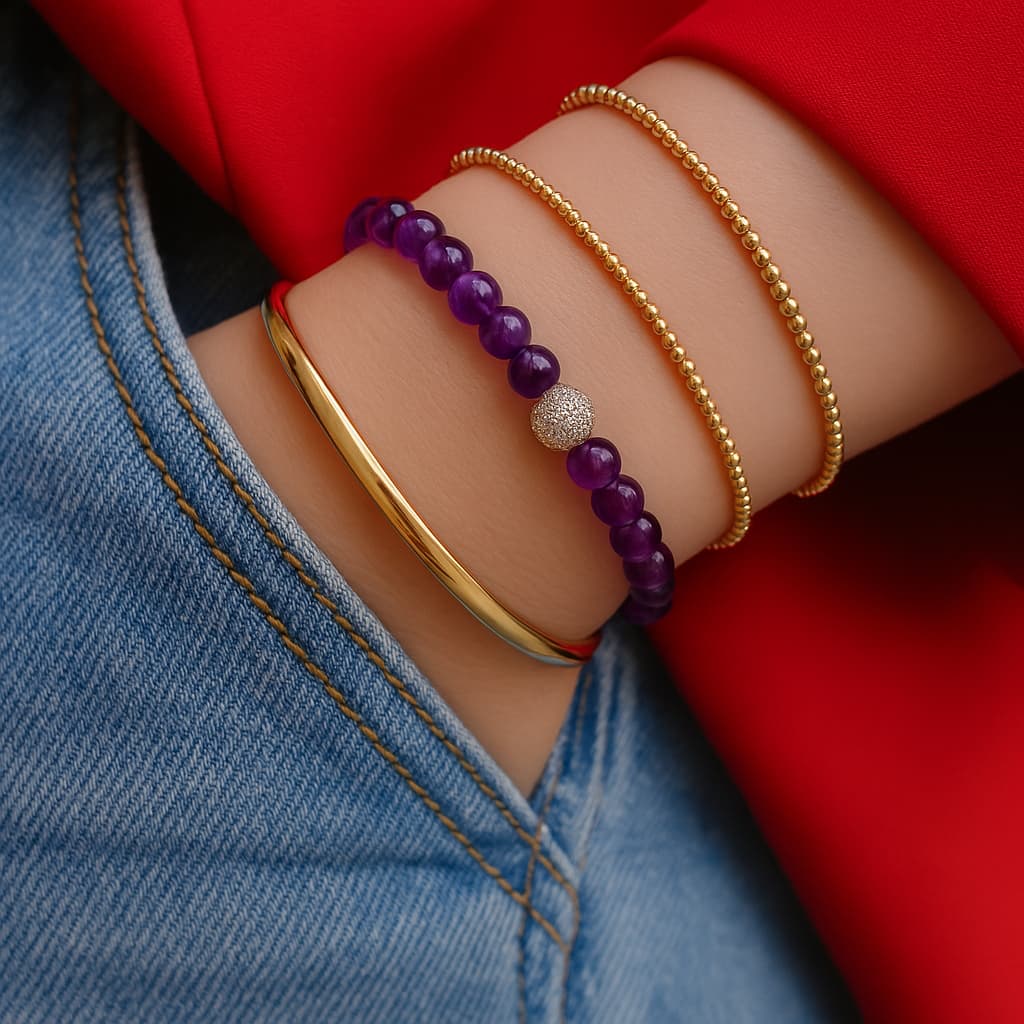 A woman wearing the Amethyst Fortune Bracelet by GinaKimKR, featuring purple amethyst stones, gold detailing, and the signature logo charm. Peaceful and stylish.