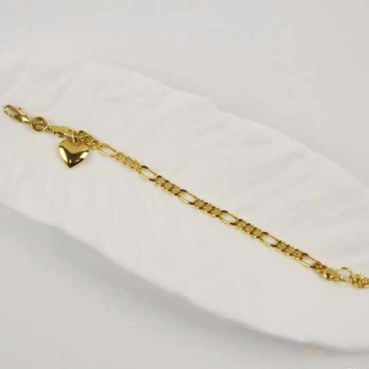 Flatlay of Evergold Figaro Heart Bracelet | GinaKimKR with polished gold heart charm and extender chain.