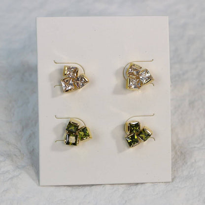 Geo Trio Earrings close-up showing gold-tone finish and clustered CZ stones in light and green hues.