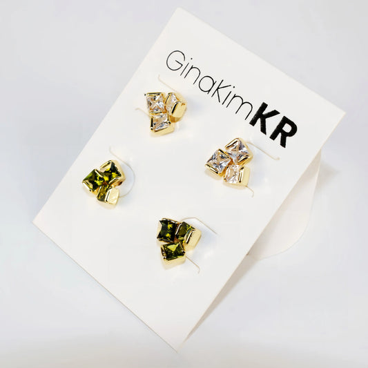 Flat lay image of Geo Trio Earring Set with three pairs of studs in clear and olive green, arranged in rows.