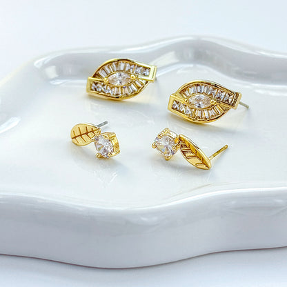 Full set of GinaKimKR gold-tone leaf earrings with various CZ cuts arranged side by side for product detail.