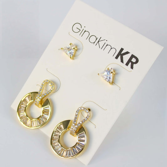 Golden Edge Duo by GinaKimKR – Elegant 2-pair earring set with triangle CZ studs and baguette crystal gold loop drops, shown on brand card