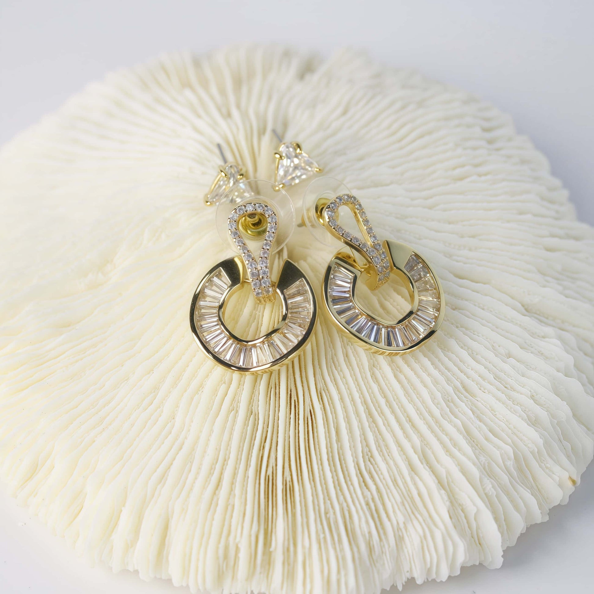 Top view of GinaKimKR’s Golden Edge Duo earrings, showing CZ triangle studs and gold crystal loops