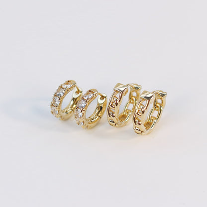 Side view of Golden Gleam Huggie Set featuring four gold hoop styles, including crystal and braided designs, arranged on a textured white background.