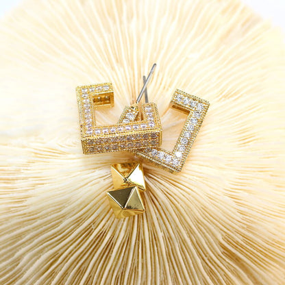 Pyramid post earring close-up from Golden Structure Set – bold gold tone with mirror shine