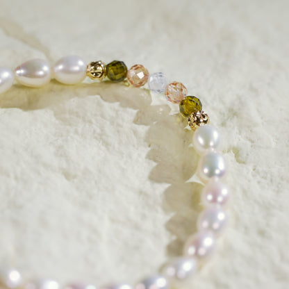 Close-up of the Harmony Light Bracelet showing alternating crystal CZ beads and pearls, finished with gold-plated accents on a softly lit fabric background.