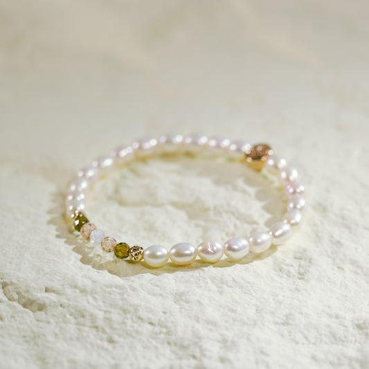 A pearl and crystal CZ stretch bracelet with gold-plated accents. Elegant and grounding, handmade by Gina Kim Jewelry.

