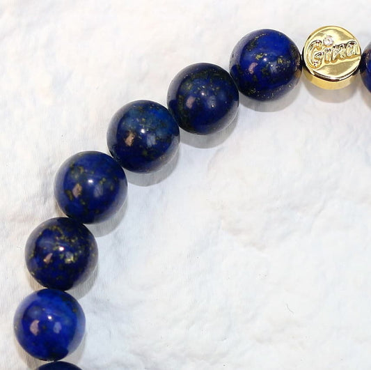 Close-up side shot of the Lapis Strength Bracelet showing 8mm beads with visible texture and a gold-tone Gina tag for a refined finish.