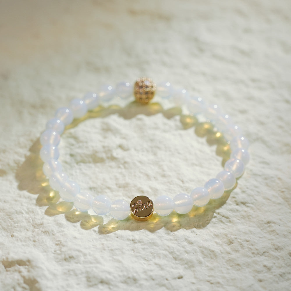 Handmade bracelet with round moonstone beads, gold-plated CZ accent, and GinaKimKR tag. Designed to soothe and inspire inner clarity.