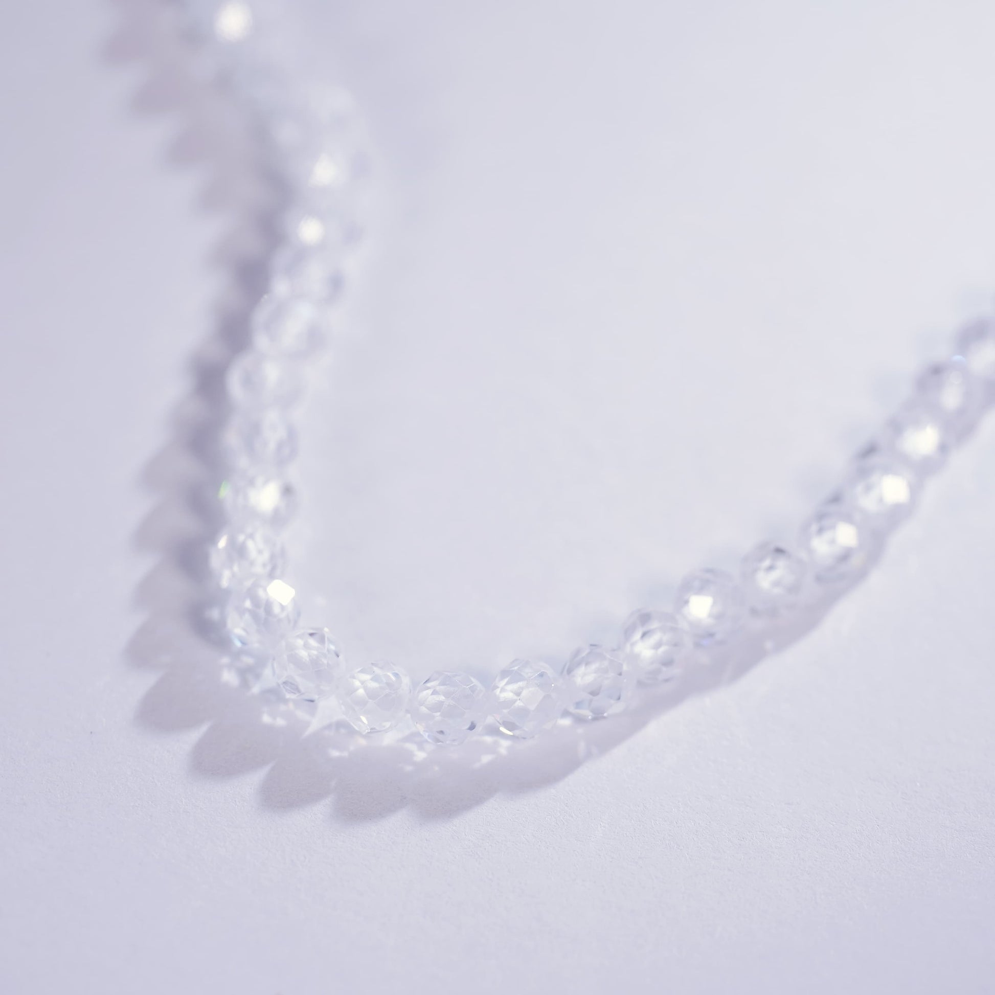 Close-up of the Morning Light Necklace laid on a light purple surface, showing faceted CZ clarity and minimalist Korean design by GinaKimKR.