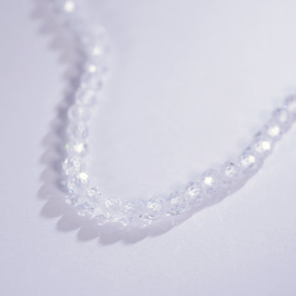 Close-up of the Morning Light Necklace laid on a light purple surface, showing faceted CZ clarity and minimalist Korean design by GinaKimKR.