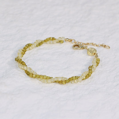 Close-up of Olive Prism Bracelet featuring light green and clear square CZ beads, braided with a gold clasp and extender, adding natural sparkle to any outfit.