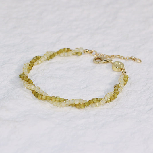 Close-up of Olive Prism Bracelet featuring light green and clear square CZ beads, braided with a gold clasp and extender, adding natural sparkle to any outfit.