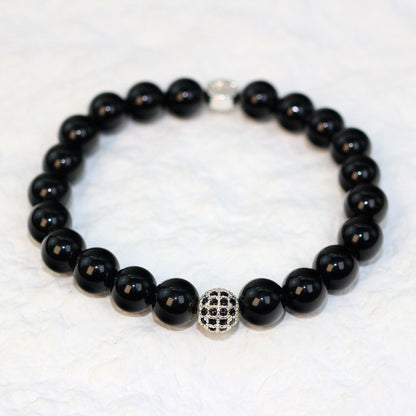 Front-facing shot of the Onyx Strength Bracelet showcasing the deep black hue and shine of 8mm round natural onyx beads.