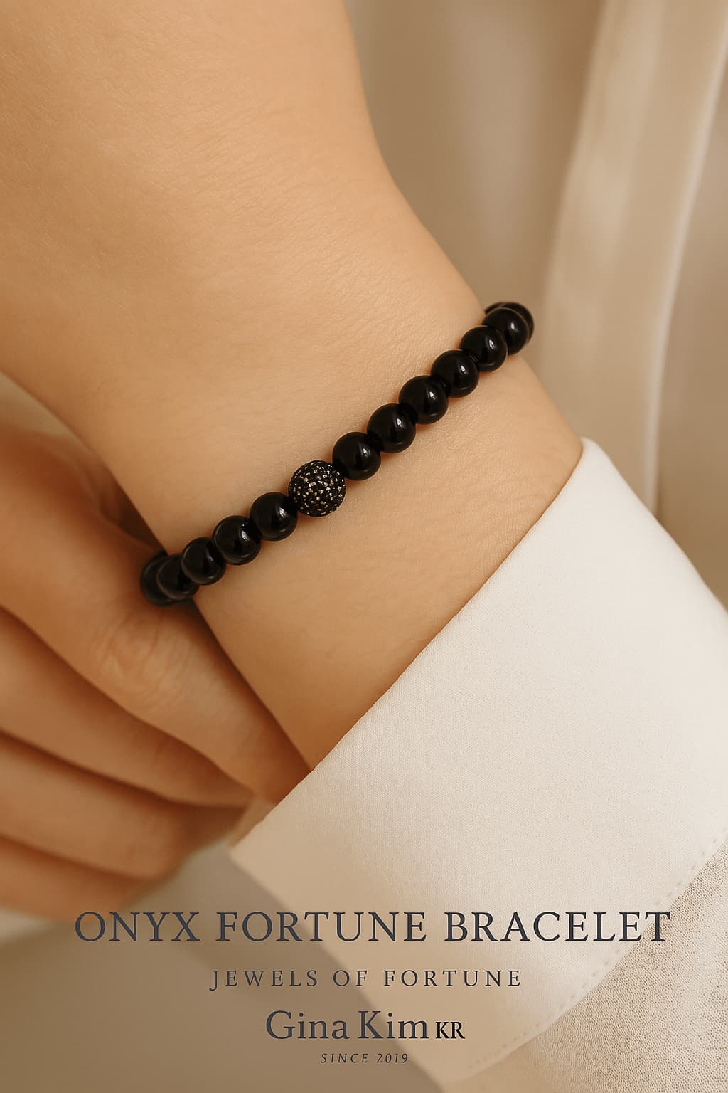 A woman wearing the Onyx Fortune Bracelet by Gina Kim, featuring black onyx stones with a silver CZ bead and signature charm. Strong, minimal, and stylish.