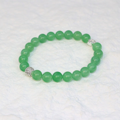 Top-down view of the Peridot Strength Bracelet featuring 8mm round beads in a refreshing green hue, neatly arranged on a white surface.