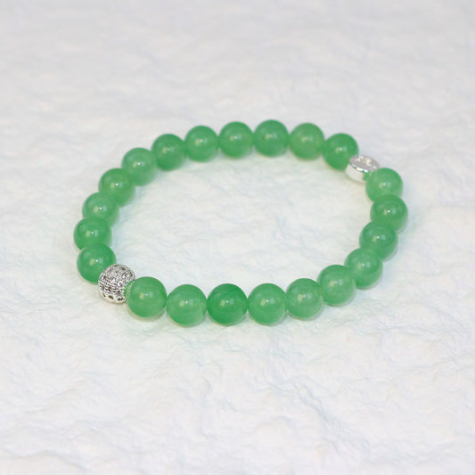 Top-down view of the Peridot Strength Bracelet featuring 8mm round beads in a refreshing green hue, neatly arranged on a white surface.