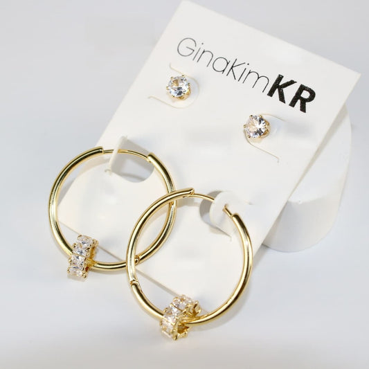 Angled view of Radiant Harmony Earring Set showing gold hoops adorned with crystals and matching 6mm CZ studs on a soft cream card. 