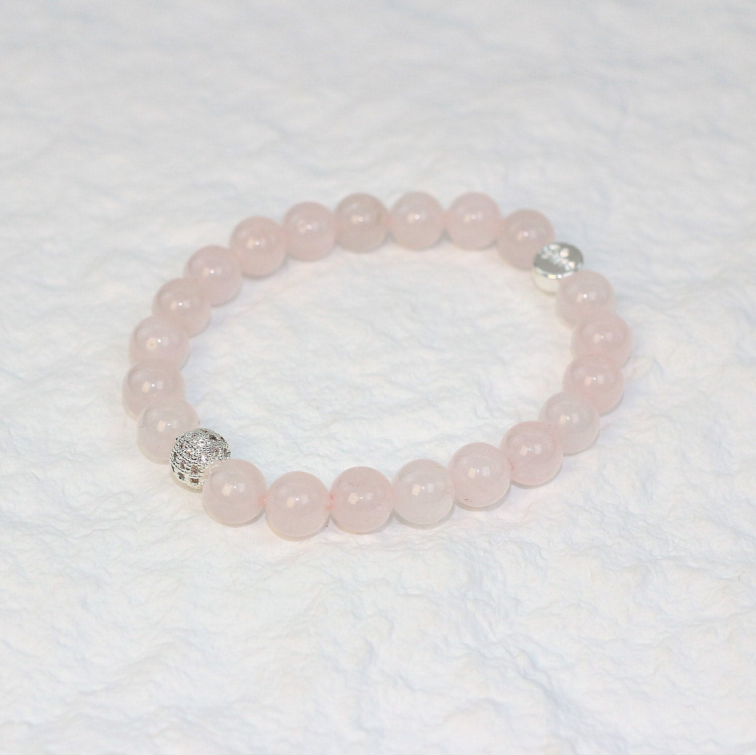 Top-down view of the Rose Quartz Strength Bracelet featuring soft pink 8mm round beads arranged in a circle, symbolizing love and emotional balance.