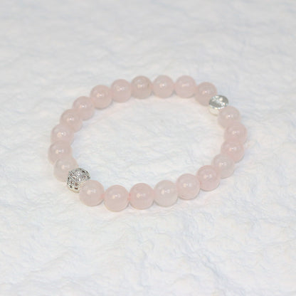 Top-down view of the Rose Quartz Strength Bracelet featuring soft pink 8mm round beads arranged in a circle, symbolizing love and emotional balance.