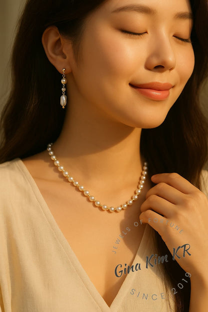 A Korean woman dressed in a linen evening dress wears the Serenity Pearl Necklace, highlighting the organic beauty of freshwater pearls and understated gold tones for a refined, luxurious look