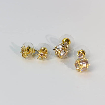 Side-angled image of Starlume Earring Set showcasing star studs and gold cage-style CZ drops.