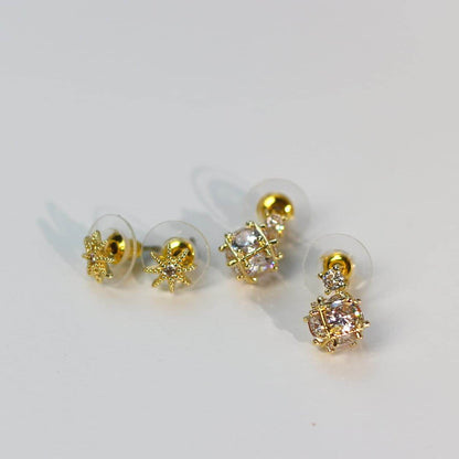 Flat lay photo of Starlume Earring Set, highlighting faceted crystals and star motifs in gold tone.