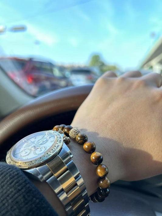Tiger’s Eye Strength Bracelet worn on wrist while driving, featuring rich golden bands and grounding energy in a casual everyday setting.