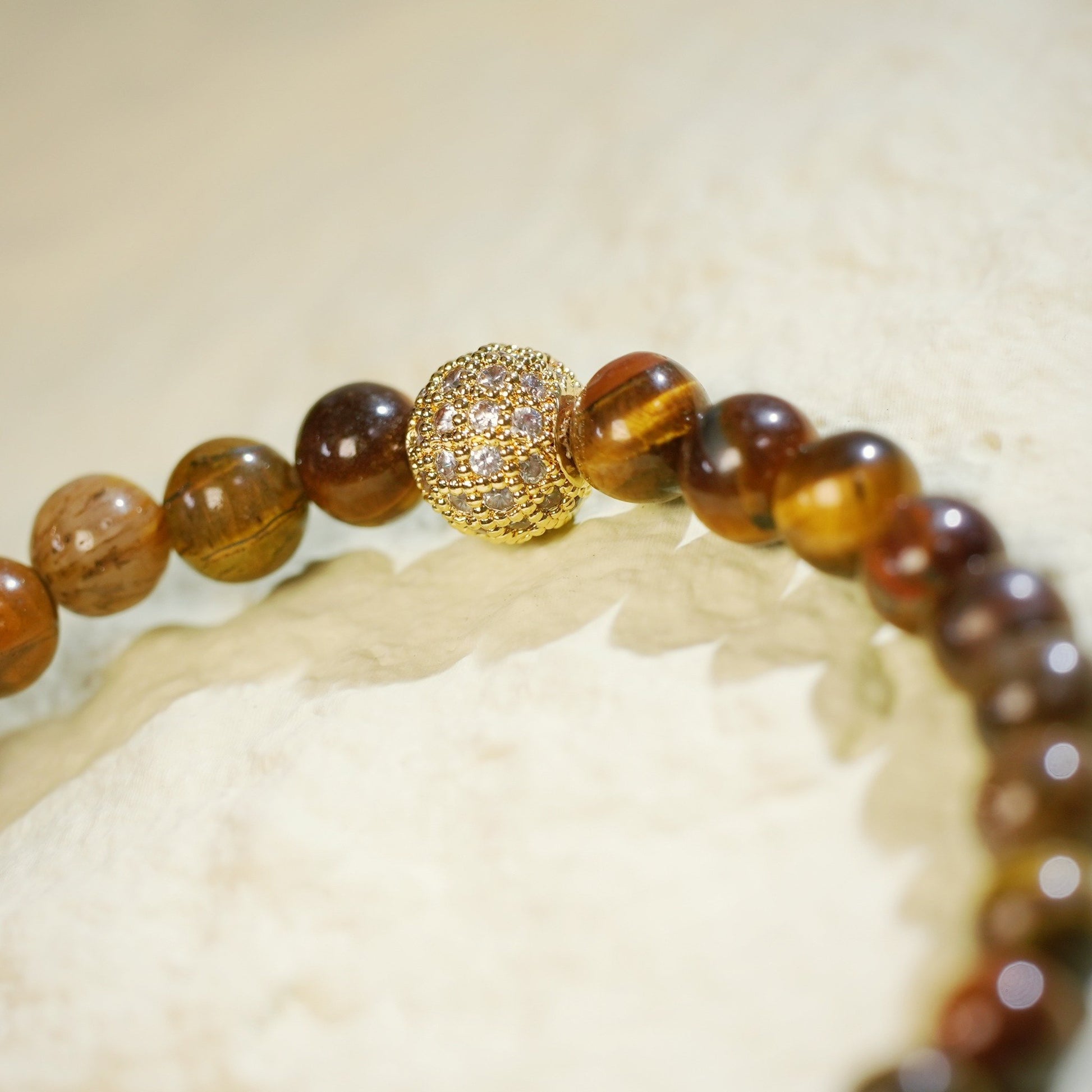 A stretch bracelet made with golden-brown tiger’s eye beads, gold-plated CZ accent, and Gina Kim logo charm. Grounding and empowering.