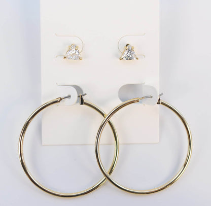 Front-facing Triad Glow Earring Set on a cream card, featuring 6mm triangle-cut CZ studs and statement 42mm gold hoops with post-back design.