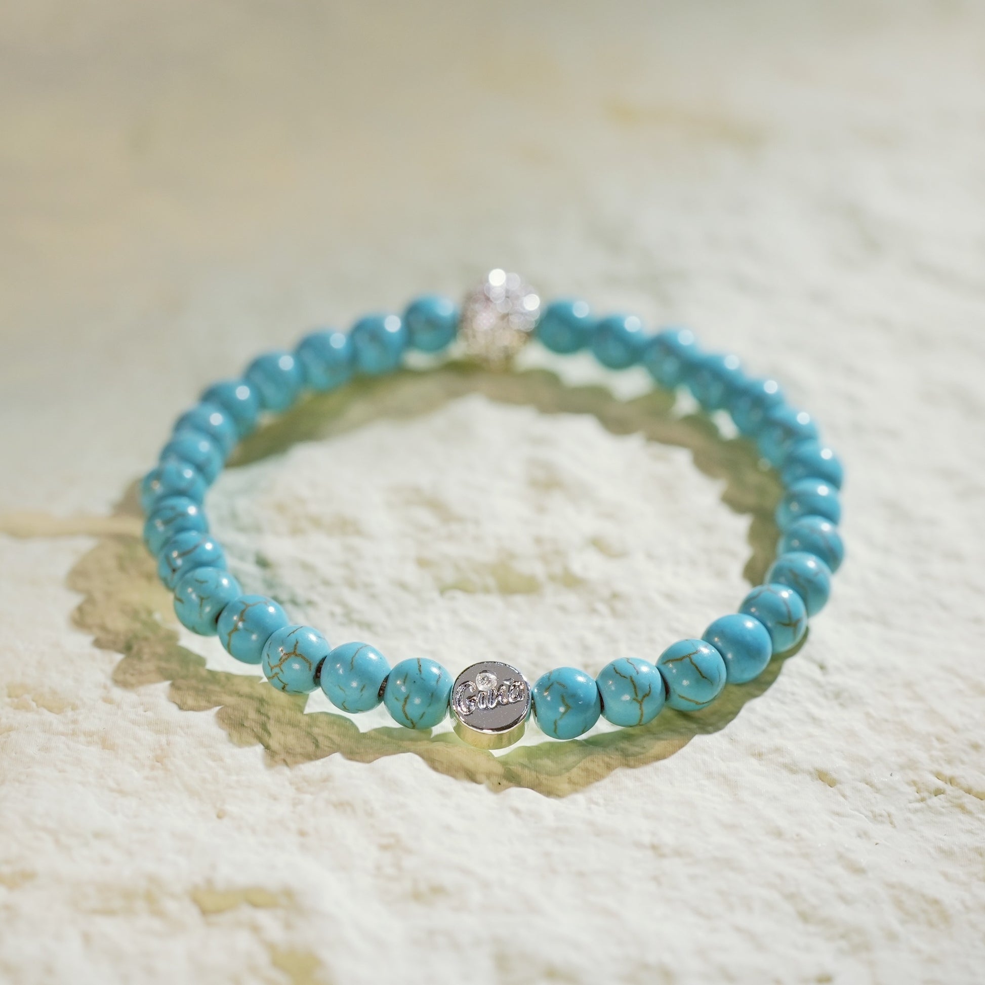 Stretch bracelet with turquoise gemstones and a sparkling gold CZ detail. Designed by GinaKimKR for everyday peace and style.