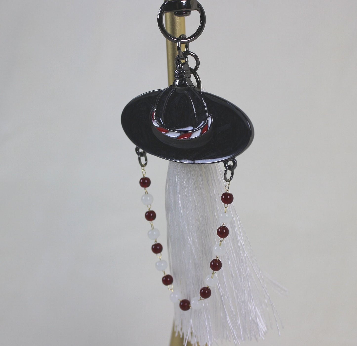 Full view of the White Spirit Hunter Key Ring showing Korean heritage inspired hat motif and RUMI like light filled mood.