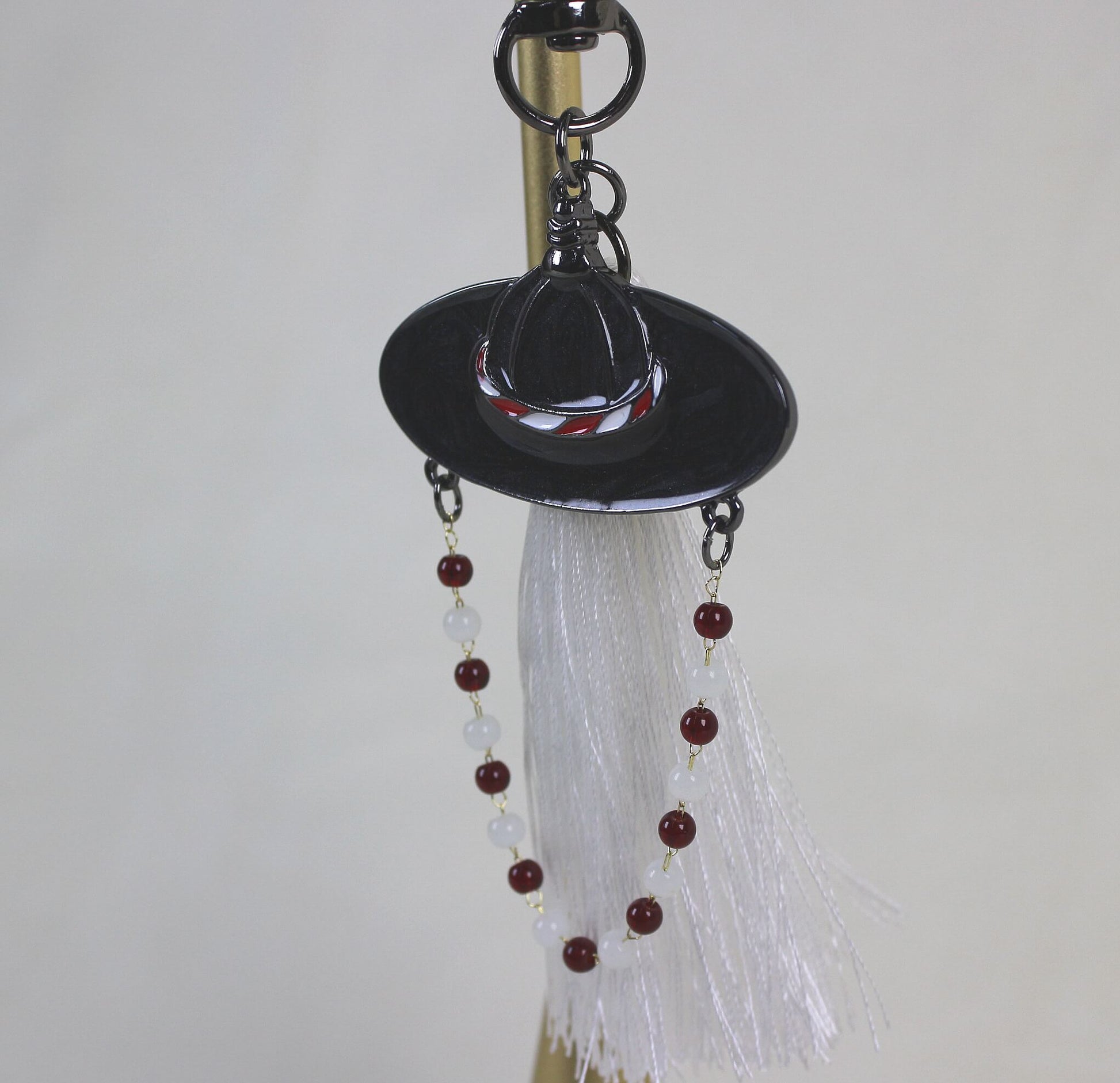 Full view of the White Spirit Hunter Key Ring showing Korean heritage inspired hat motif and RUMI like light filled mood.